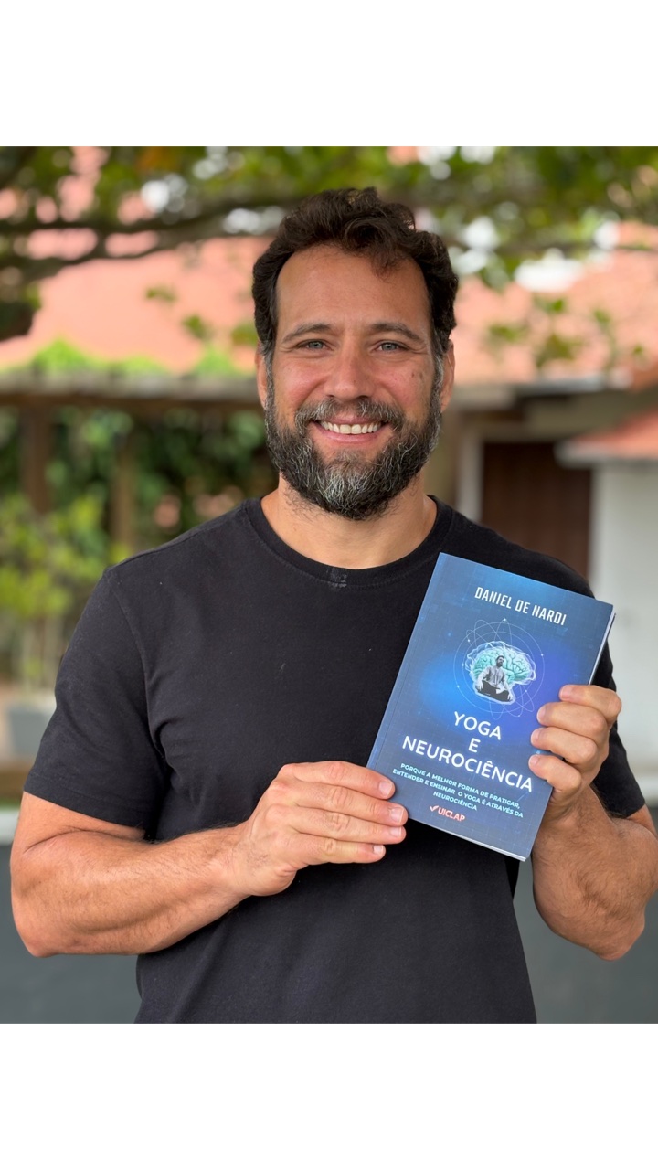 Daniel De Nardi segurando o livro Yoga e Neurociência